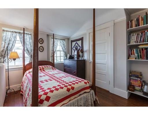 560 Jerusalem Road Cohasset, MA 02025 - Photo 23 of 30 a bedroom with a large bed and a book shelf