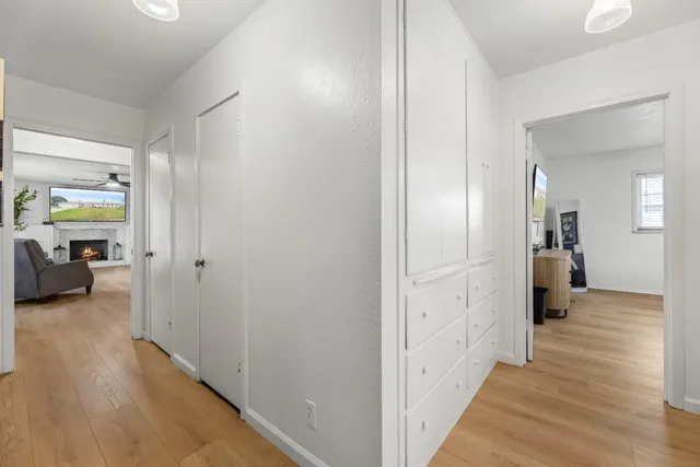 a view of a hallway with wooden floor and closet