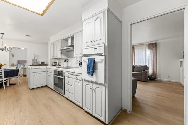 a view of a hallway with wooden floor and dining room