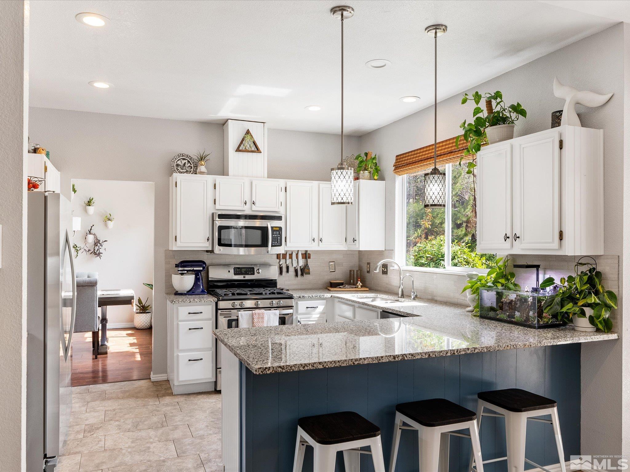 2946 Aspendale Drive Reno, NV 89503 - Photo 12 of 40 a kitchen with stainless steel appliances granite countertop a stove a sink a microwave a refrigerator and cabinets