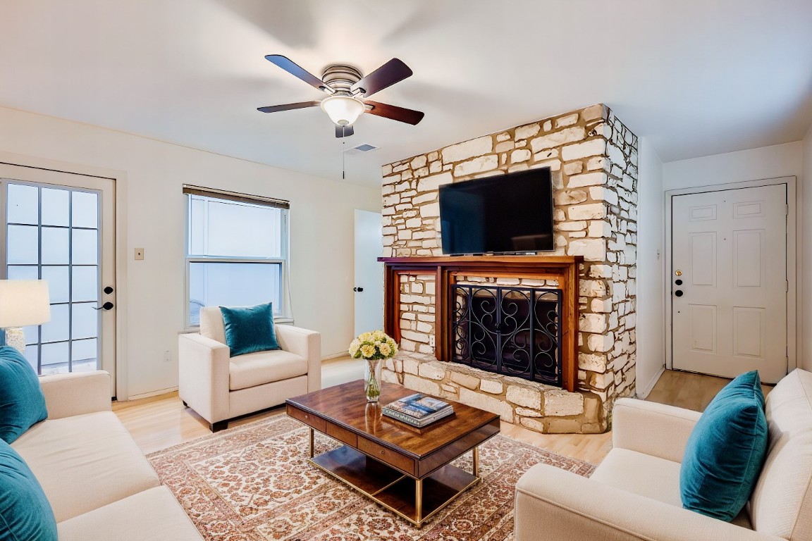 1714 Timber Ridge Road Austin, TX 78741 - Photo 1 of 1 a living room with furniture a flat screen tv and a fireplace