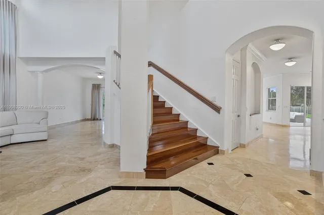 a view of staircase with white walls and glass door