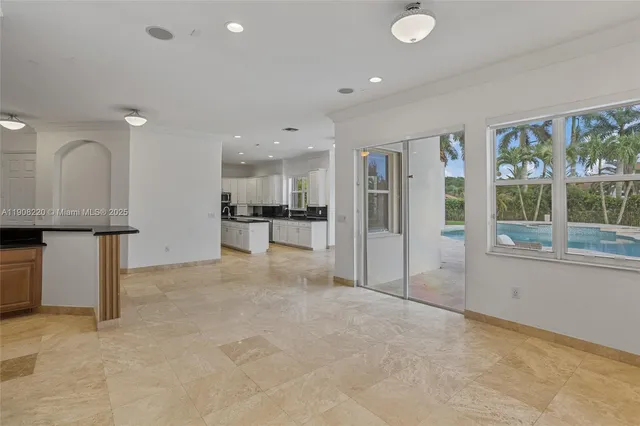 a view of a kitchen with large windows and refrigerator