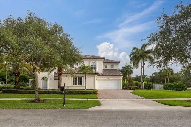 a front view of a house with a yard and trees