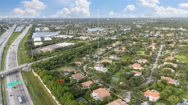 an aerial view of residential houses with outdoor space and trees