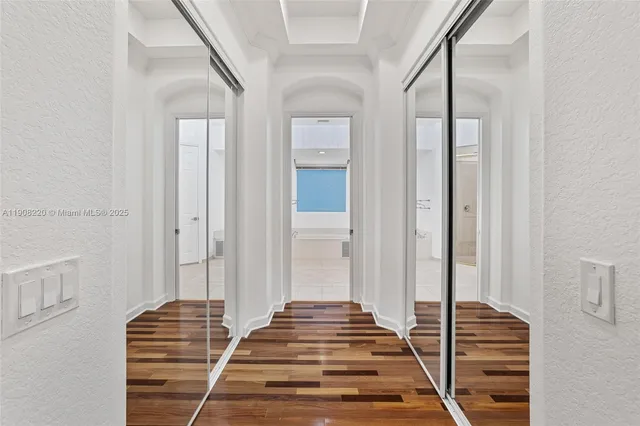 a view of a hallway with wooden floor and staircase