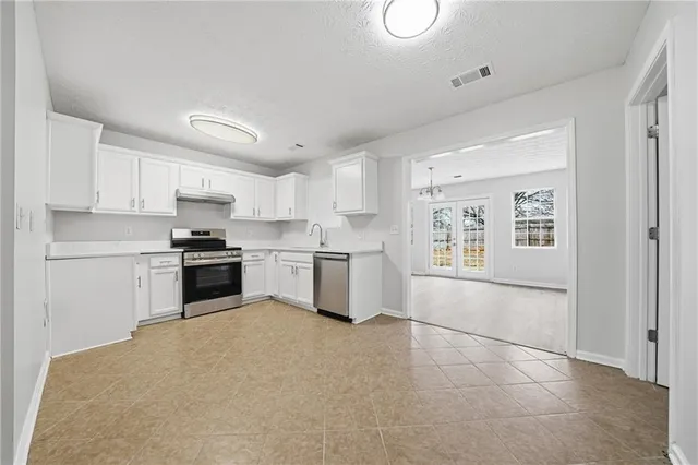 a kitchen with stainless steel appliances a refrigerator sink and cabinets