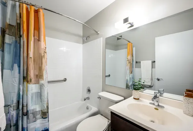 a bathroom with a sink and mirror with toilet