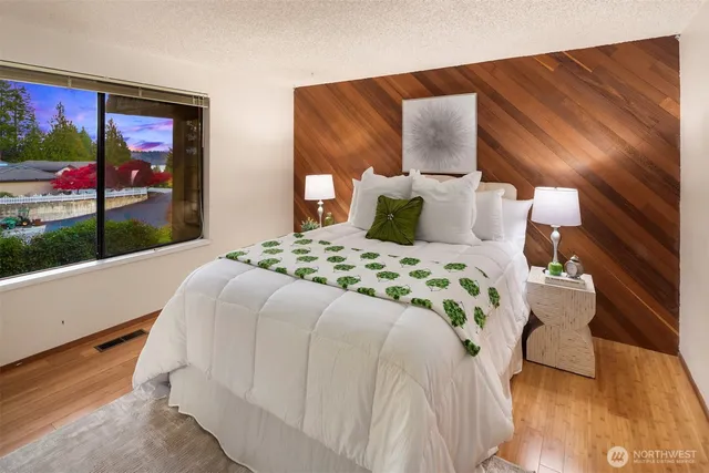 a large bed sitting in a bedroom next to a window