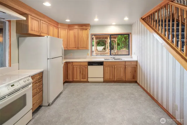 a kitchen with stainless steel appliances granite countertop a refrigerator sink and cabinets