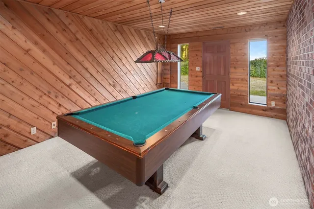 a room with pool table and windows