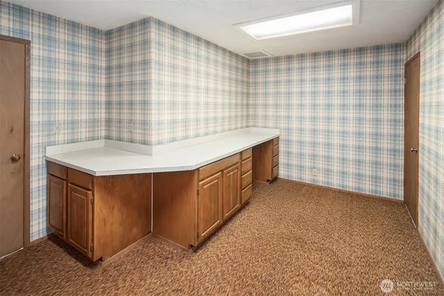 a bathroom with a granite countertop sink a vanity and a blue shower