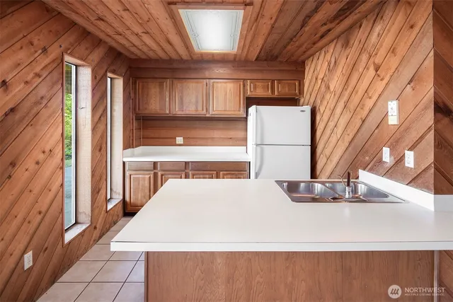 a kitchen with a sink a refrigerator and window