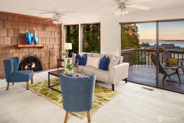 a living room with furniture a fireplace and a floor to ceiling window