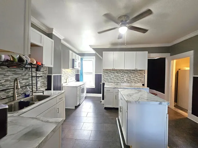 a large kitchen with a lot of counter space and wooden floor