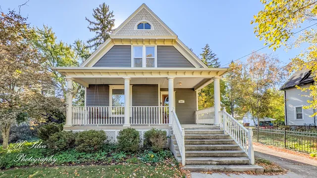 a view of a house with a small yard plants and large tree