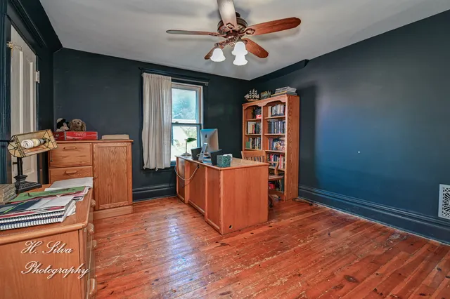 a bedroom with bed and paintings on the wall