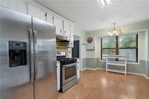 a kitchen with stainless steel appliances a stove a refrigerator and cabinets