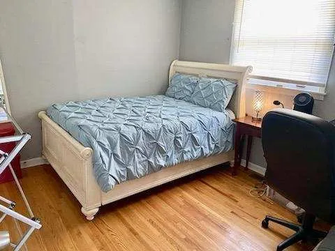 a bed sitting in a bedroom next to a window
