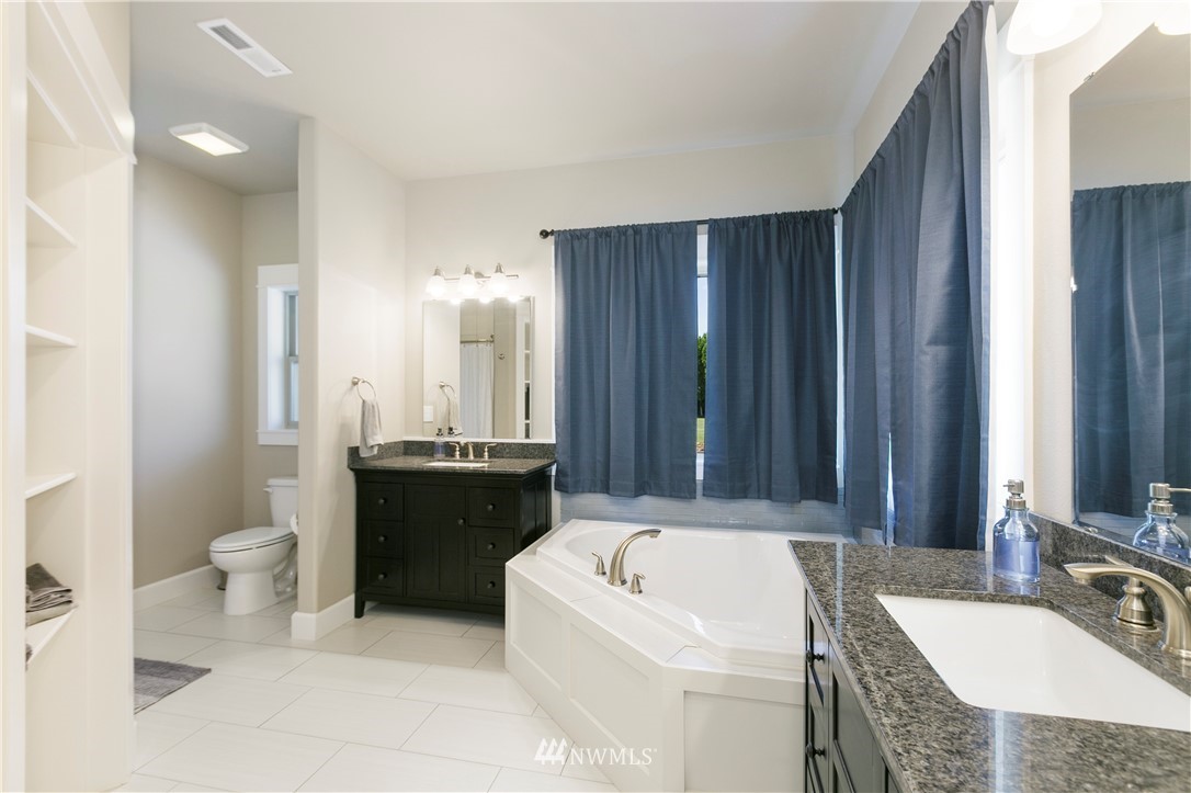 11301 Stump Road Yakima, WA 98908 - Photo 18 of 24 a bathroom with a tub a sink and a large mirror