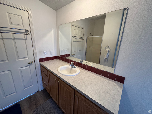 580 East 400 North Spring City, UT 84662 - Photo 24 of 40 Full bathroom featuring a textured wall, vanity, a stall shower, and dark wood finished floors