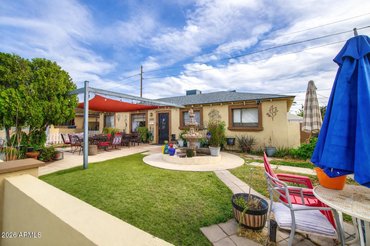3107 West Montebello Avenue Phoenix, AZ 85017 - Photo 3 of 30 a backyard of a house with yard table and chairs