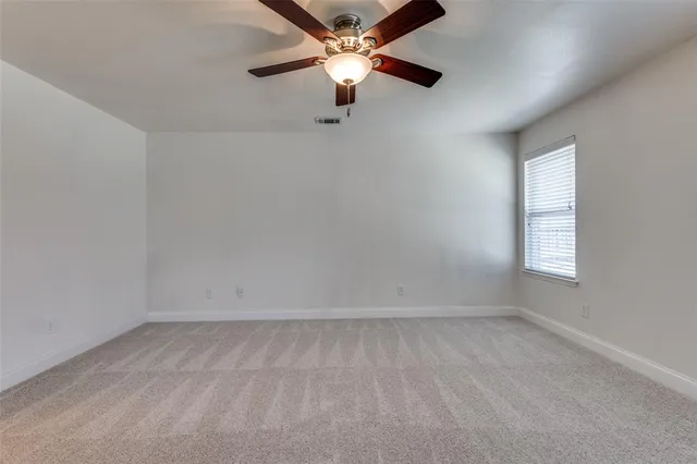 an empty room with a window and a ceiling fan