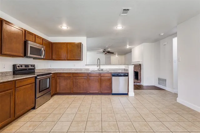 a kitchen with stainless steel appliances granite countertop a stove a sink and a microwave