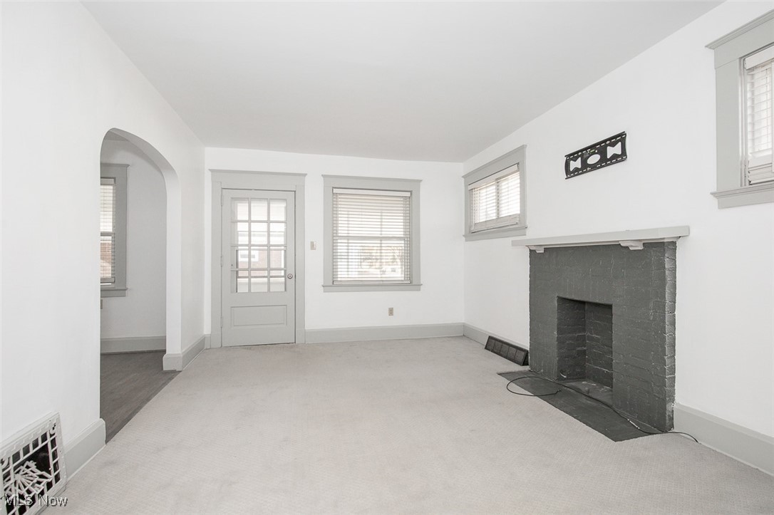 1604 Hampton Road Akron, OH 44305 - Photo 12 of 30 Unfurnished living room featuring carpet floors, arched walkways, and a fireplace