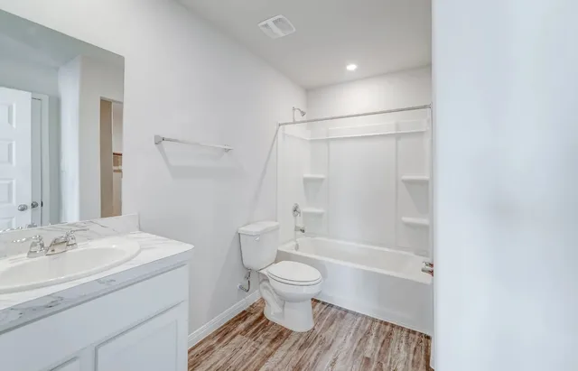 a bathroom with a sink a toilet and a large mirror