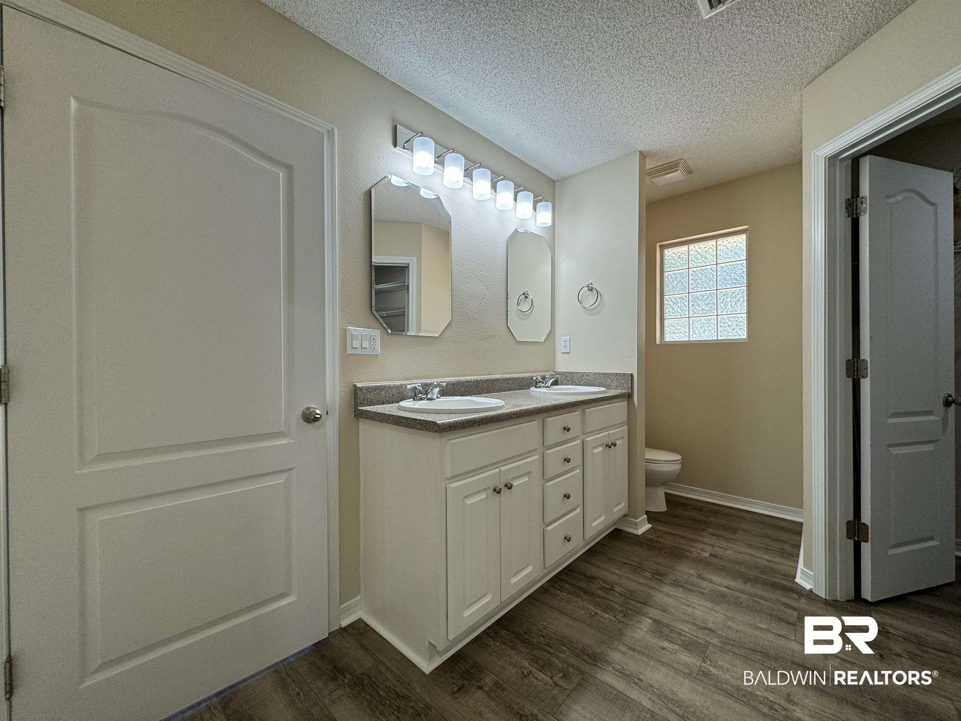 32769 Arbor Ridge Circle Lillian, AL 36549 - Photo 17 of 36 Bathroom featuring a textured ceiling, hardwood / wood-style floors, vanity, and toilet
