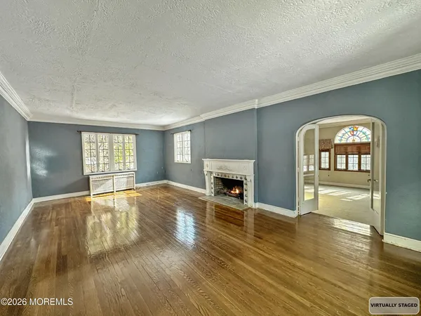 a view of empty room with wooden floor and fireplace