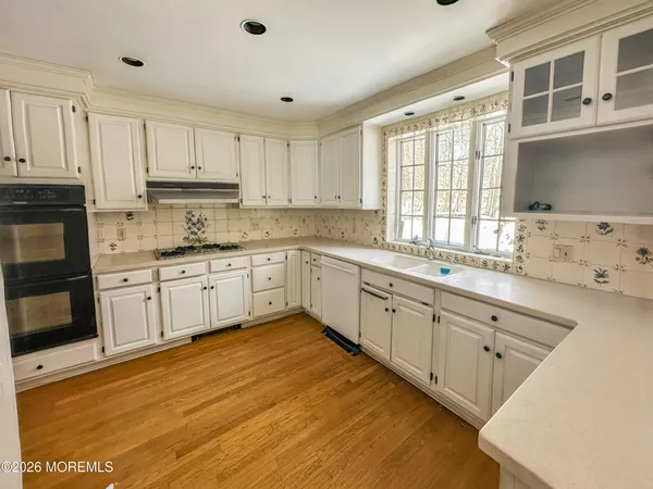 a large kitchen with granite countertop white cabinets and white appliances