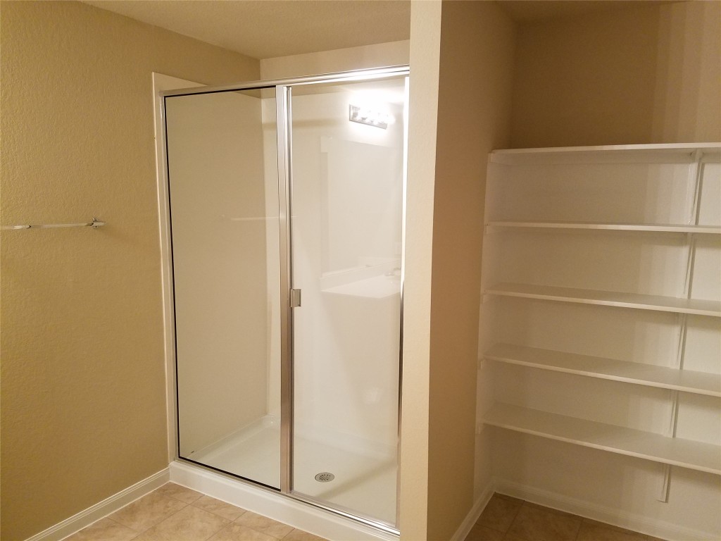 5905 Montrelia Drive Austin, TX 78724 - Photo 13 of 25 a bathroom with a glass shower door
