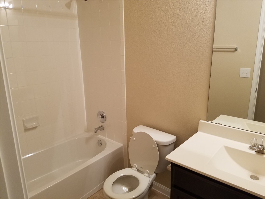 5905 Montrelia Drive Austin, TX 78724 - Photo 15 of 25 a bath room with a toilet a sink and a bath tub