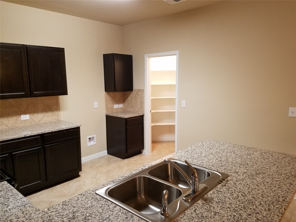5905 Montrelia Drive Austin, TX 78724 - Photo 7 of 25 a kitchen that has a sink and a stove in it