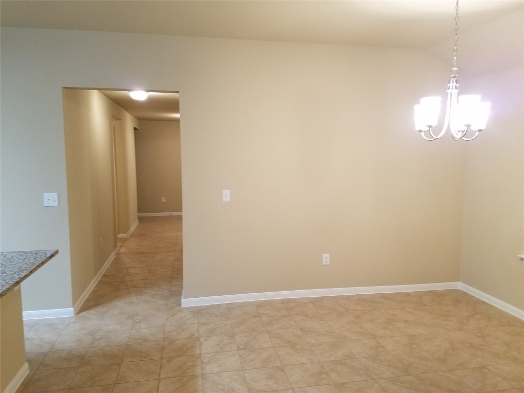 5905 Montrelia Drive Austin, TX 78724 - Photo 9 of 25 an empty room with chandelier fan and windows