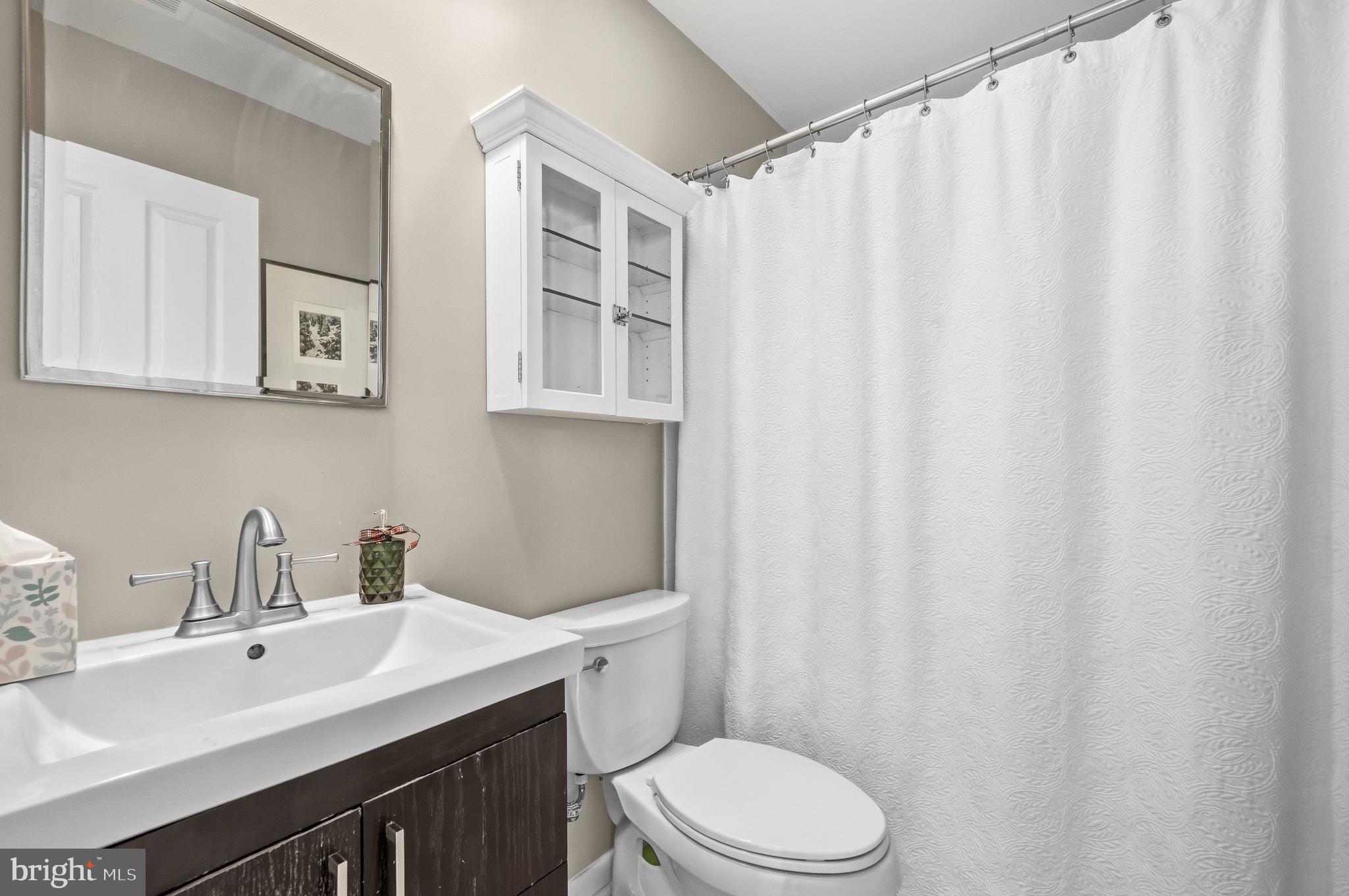 2116 12th Street Northwest Washington, DC 20009 - Photo 23 of 35 a bathroom with a sink a toilet and shower curtain