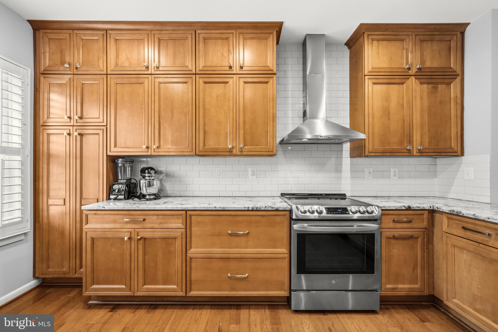 2116 12th Street Northwest Washington, DC 20009 - Photo 10 of 35 a kitchen with granite countertop cabinets stainless steel appliances and wooden floor