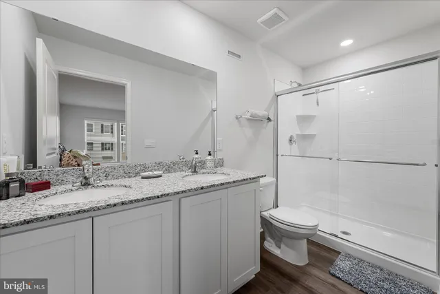 a bathroom with a granite countertop sink toilet and shower