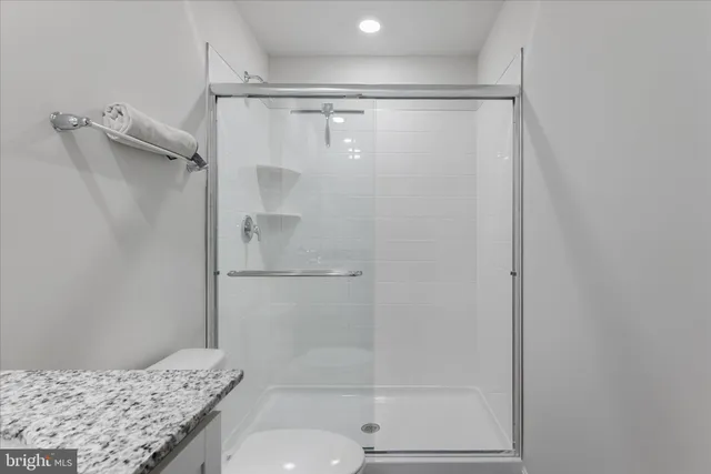 a bathroom with a granite countertop shower and a sink