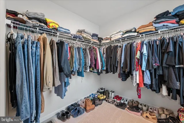 a view of walk in closet with clothes