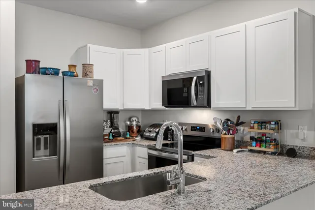 a kitchen with stainless steel appliances granite countertop a refrigerator sink and microwave