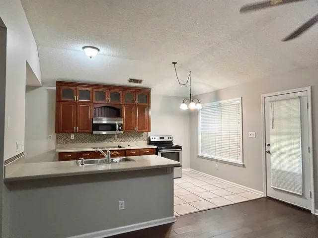 a kitchen with stainless steel appliances granite countertop a sink a stove and a refrigerator