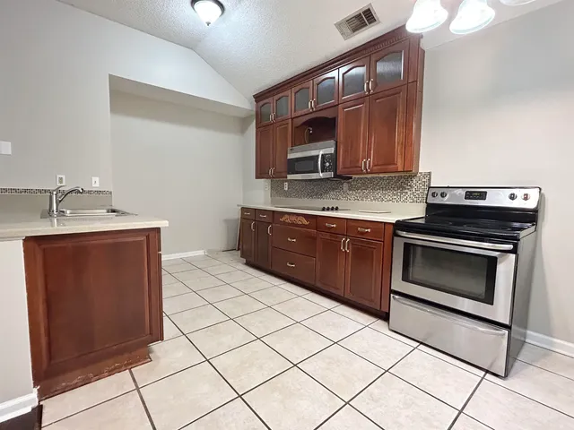a kitchen with stainless steel appliances a stove a sink and a microwave