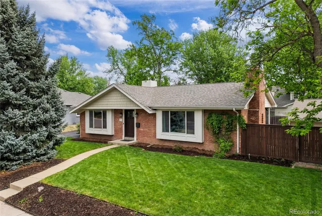 a living room with furniture a fireplace and a dining table with wooden floor