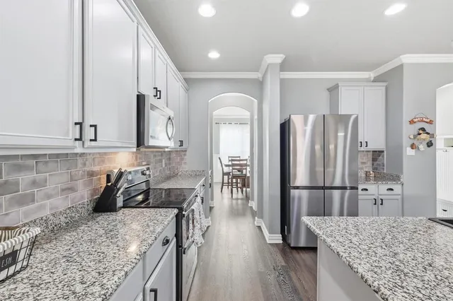 a kitchen with stainless steel appliances granite countertop sink refrigerator and microwave