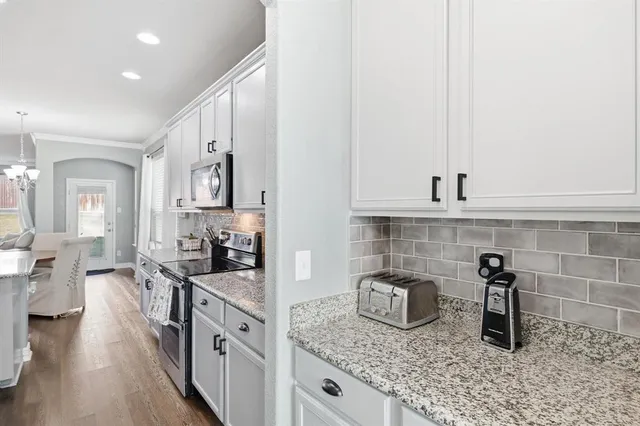 a kitchen with sink stove and cabinets