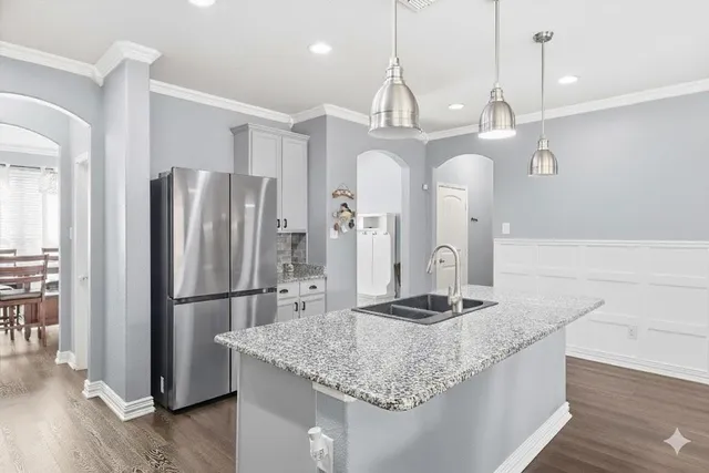 a kitchen with stainless steel appliances granite countertop a refrigerator a sink and a stove