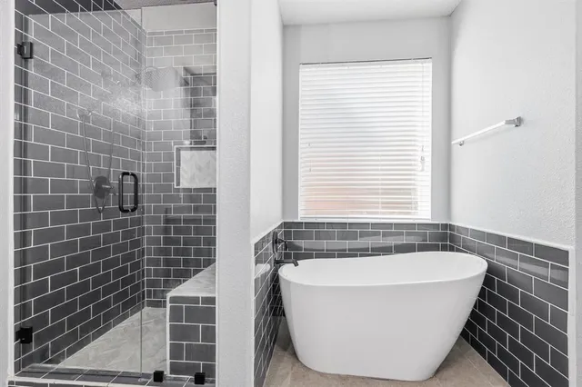 a white bath tub sitting in a bathroom next to a window